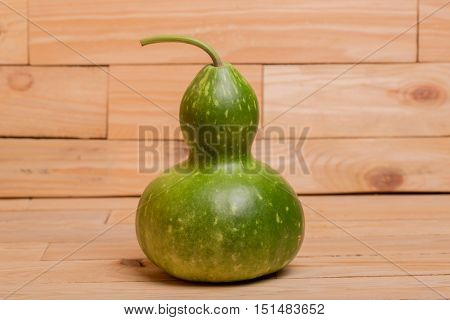 green calabash or Chinese Bottle Gourd is used by many cultures around the world for many different purposes, on a wooden table