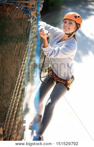 I like extreme sport. Active good looking delighted woman holding on to the rope and moving forward while taking pleasure in the high risk activities