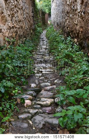 Narrow Village Alley With Stone Walls