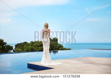 Beautiful Bride Wedding Portrait. Elegant Blond Woman With Long Wavy Hair Wearing In White Fashion M