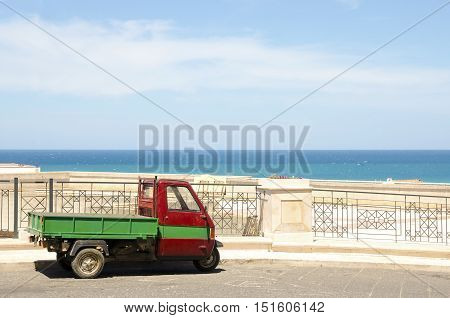 Three wheeler vehicle background sea blue sky
