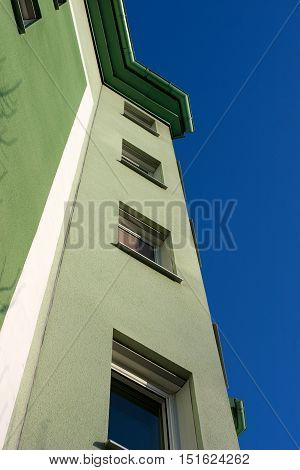 The green facade striving upwards towards the blue sky.