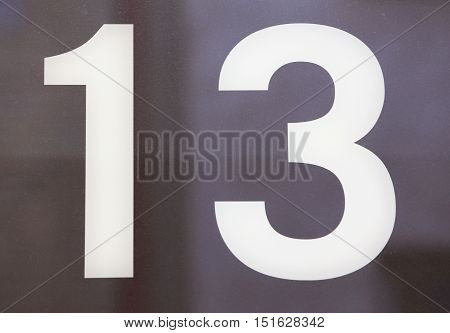 Number 13 in white on a glass wall.