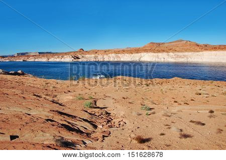Houseboat is docked along the beautiful sandstone rocks and cliffs of the Glen Canyon National Recreation Area in Arizona.