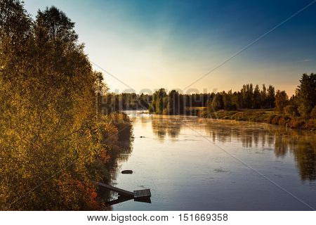 A beautiful but cold morning by the river Pyhajoki in the Northern Finland. The autumn is here and the leaves are colored beautifully.
