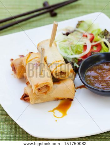 Spring rolls with vegetables, sweet mango chili sauce. Asian cuisine Outdoor background
