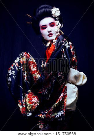 Young beautiful asian woman's portrait, geisha in kimono on black