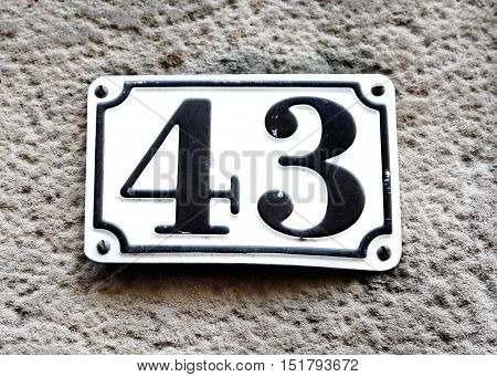 Sign with the house number 43 on a house wall.