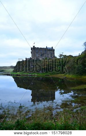 Dunvegan Castle reflected in Loch Dunvegan in Scotland.