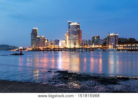 Night view of skyscrapers beside Xiamen coast, China