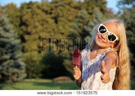 Little girl with sungkasses holding pink ice cream