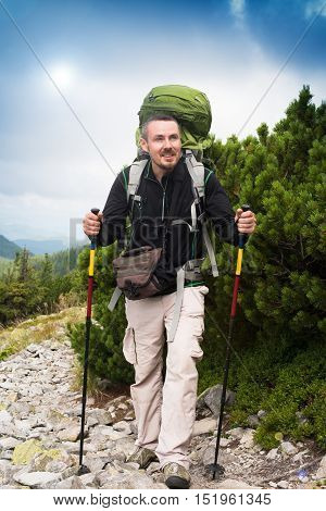 Hiker. Happy hiker. Hiker mountain. Hike.Hiking. Concept success. Hiker sunset. Hiker smiling. Tired tourist. Tired hiker. Concept freedom. Concept inspiration. Winning life goal. Healthy lifestyle.