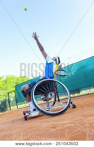 Disabled Tennis Player Hits The Ball For Service