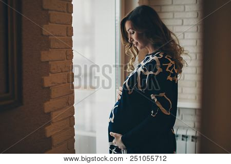 A Pregnant Woman Looking Out The Window