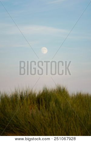 Moon Rises Over The Dunes As The Sunsets