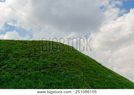 Summer Background. Warm Sunny Weather On A Green Grass Hill. A Blue Sky With White Clouds