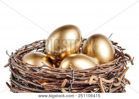 Golgen Eggs In A Basket Of Birch Branches. Painted Easter Chicken Egg In The Brown Nest