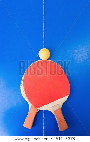 Pair Of Old Pingpong Rackets And A Ball On A Blue Pingpong Table