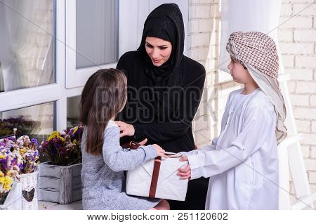 Arabic Mother Giving Gift To Her Boy And Girl.muslim Family.