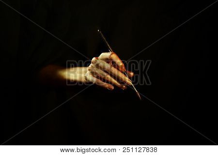 Golden Hand With Brush On Black Background