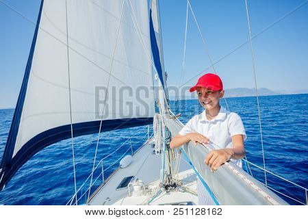Cute Boy On Board Of Sailing Yacht On Summer Cruise. Travel Adventure, Yachting With Child On Family