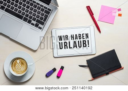 Wir Haben Urlaub Written In German On Tablet Meaning Closed For Holidays As Flatlay From Above Of An