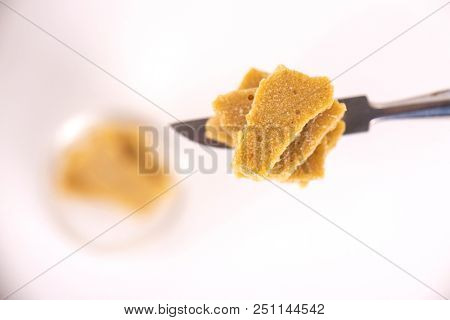 Detail of cannabis concentrate extracted from the marijuana plant for medical use, isolated over white background