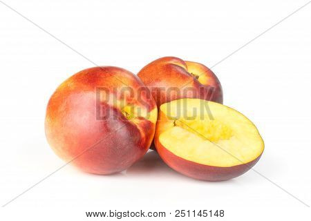 Group Of Two Whole One Half Of Ripe Deep Red Nectarine Isolated On White