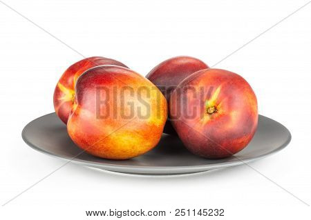 Lot Of Whole Ripe Deep Red Nectarine On A Grey Ceramic Plate Isolated On White