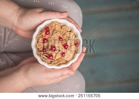 Woman Holding Bowl Of Tasty Cereal Corn Flakes With Red Currant Berries From Above Healthy Delecious