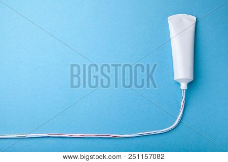 Colored Toothpaste Squeezed Out Line From Tube On Blue Background