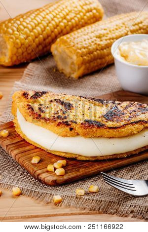 Wooden Table With Several Ingredients For The Preparation Of Cachapas With Cheese, Corn, Butter, Gro