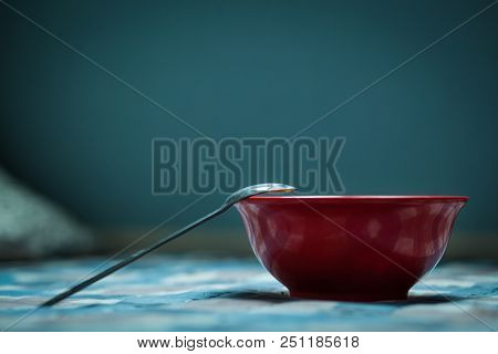 Blue Background, A Lot Of Empty Space, A Rounded Plate Deep, A Metal Spoon, Utensils, For The Kitche