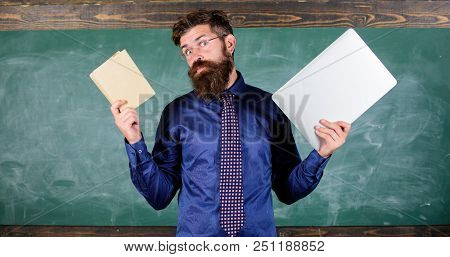 Stay Modern With Technology. Teacher Bearded Hipster Holds Book And Laptop. Modern Technologies Bene