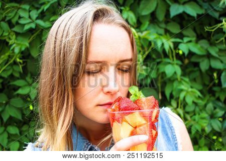 The Girl Is Happy To Breathe In The Aroma Of Fresh Fruits That Are Cut Into Pieces And Put Into A Co