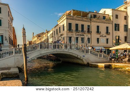 Venice / Italy - May 25, 2018: Tourists Enjoy The Warm Evening Sun And The Scenic View In Ponte Dell