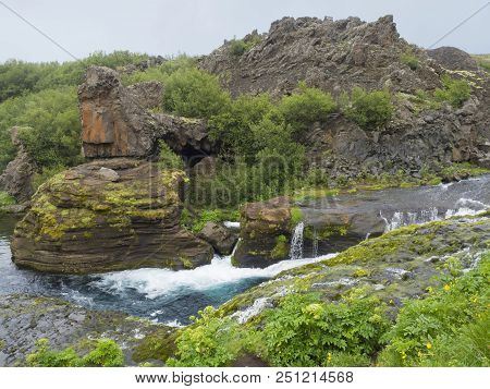 Beautiful Valley Gjain With Colorful Lava Rocks, Green Vegetation And Blue Water Stream Cascade In S