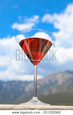 A Glass Of Red Martini On The Sky Background. Vertical. Close Up.