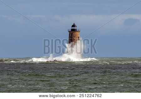 During A Unique High Tide A Huge Wave Wraps Around The Stone Tower Of Whaleback Lighthouse In Maine.