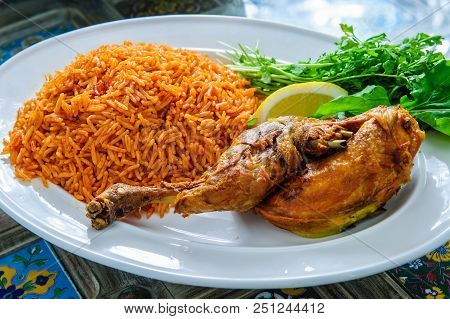 Plate Of Rice With Duck Leg And Greens.