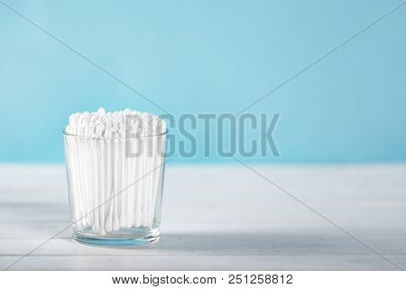 Cotton Swabs In Clear Glass Jar On Pastel Blue Background. Copy Space