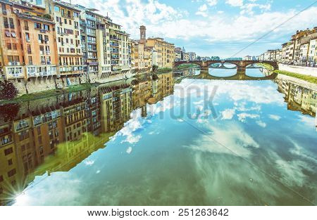 Old Buildings And Beautiful Ponte Santa Trinita Mirrored In The River Arno, Florence, Tuscany, Italy