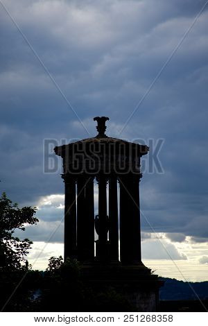 Silhouette Of Calton Hill Monumner With A Moody Sky In The Background