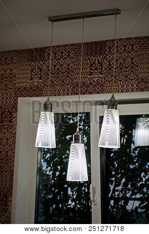 A White Decorative Lamp Hangs From The Ceiling. A Modern Chandelier In The Kitchen.