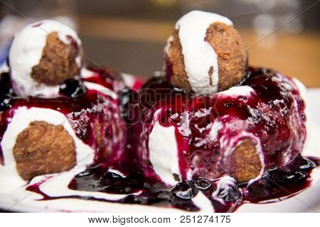 Papanasi - A Traditional Romanian Dessert. The Cake Is Made From Three Donuts Covered In Sour Cream 
