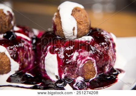 Papanasi - A Traditional Romanian Dessert. The Cake Is Made From Three Donuts Covered In Sour Cream 