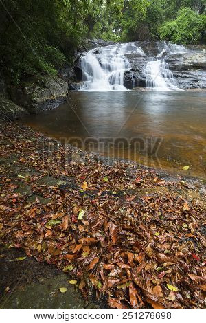 River Flowing Over Wet Rocks And The Debengeni Waterfall