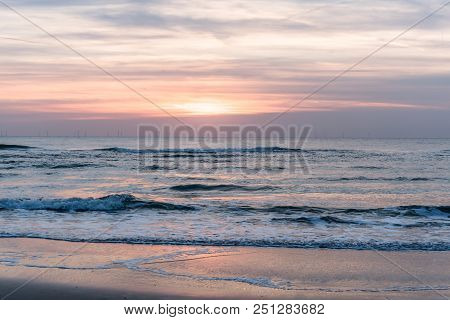 Purple Sunset At The Seaside, With The Offshore Windpark Egmond Aan Zee  At The Horizon. The Netherl