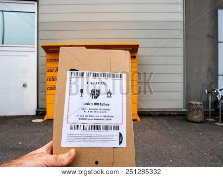 Strasbourg, France - Mar 17, 2018: Hand Holding Parcel Package In Front Of Amazon Locker Orange Deli