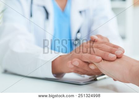 Hand Of Doctor Reassuring Her Female Patient. Medical Ethics And Trust Concept